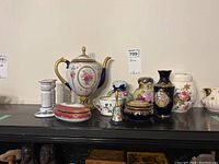 Full view showing all items including Faberge Egg Imperial Teapot, Sadler jar, Limoges vase, trinket boxes, candlesticks, small bell, and shakers.