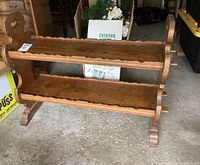 Front view of the wooden two-tier shelf showing the scalloped edges on both shelves and carved side panels.