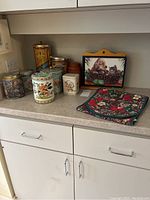 Overview of all tins, table runner, and wooden key box arranged on kitchen counter