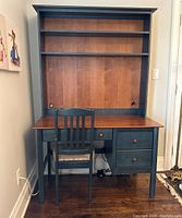 Front view of desk with shelving and matching chair showing two drawers and three shelves