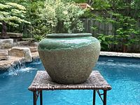 Centered front view of planter on wicker table by pool