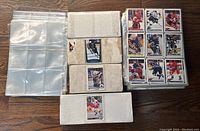 Photo showing multiple hockey cards in plastic sleeves within white binders, plus extra blank plastic inventory card sleeves.