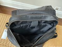 Open top compartment showing black nylon interior and zipper closure.