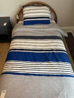 Single bed made up with the Lacoste bedding set showing comforter pattern and pillow