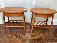 Front view of both round teak end tables side by side