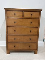 Front view of dresser showing six drawers and wood finish