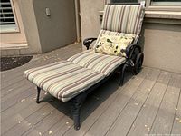 Full side view of chaise lounge on deck showing frame, wheels and cushions