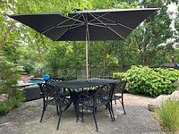Full set on patio showing table, six chairs, umbrella and base