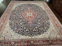 Full overhead view of entire rug on wooden floor showing overall pattern and border