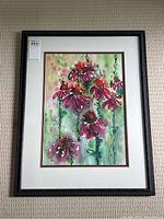 Full view of framed colorful abstract floral watercolour painting hung on wall.