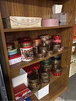 Shelf view showing multiple cookie tins in various sizes and designs including holiday and floral patterns