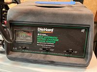 Front view of DieHard battery charger showing the microprocessor-controlled panel and ammeter gauge.