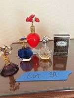 Top view of four perfume bottles including purple, blue, clear, and red bottles along with boxed Pfeffer cologne