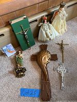 Photo showing all religious items in the lot arranged on the floor including crucifixes, statues of crowned figures, and a small figurine of Jesus' head.