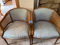 Pair of mid century armchairs with cane wood frame and blue upholstery, showing wear on fabric