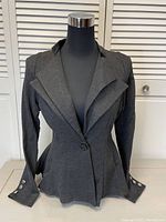 Front view of a grey heather Hybrid & Company womens jacket with double lapel and fitted waist on mannequin.
