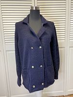 Front angled view of the navy and silver double-breasted sweater jacket on a mannequin.