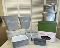 Photo of storage and organization items including metal IKEA boxes, colorful cardboard boxes, fabric bins labeled 'things', and various plastic containers.