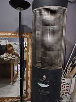Full view of the black torchiere floor lamp showing the tall pole, bowl-shaped lampshade, pull chain switch, and round base.