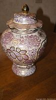 Front view of the 13-inch Chinese porcelain jar showing floral designs and lid with gold finial on top.