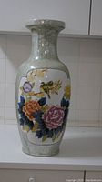 Side view of large porcelain floor vase showing crackle glaze and colorful floral and bird painting