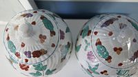 Top view showing colorful floral and rabbit elements on white ribbed surface and lid knob.