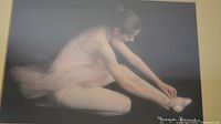 Full view of the framed print showing a ballet dancer adjusting her ballet shoe.