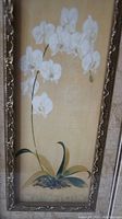 Full view of the framed print showing white orchids and the ornate frame.