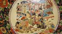 Close-up photo showing detailed hand-painted traditional Japanese figures and landscape scene on inside bottom of the bowl.
