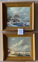 Two framed winter scene paintings stacked vertically, showing the ice skating scene on top and snowy landscape below.