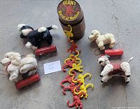 Four vintage plush walking dogs and a large Barrel of Monkeys game arranged on a floor, showing the entire lot contents.