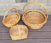 Photo showing all three baskets together on wooden surface, highlighting shape and woven texture