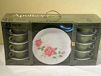 Original sealed box displaying cups stacked on left and right sides, middle shows plate with rose floral design