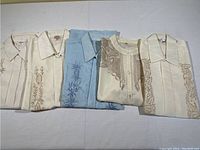 Five Filipino dress shirts laid flat showing embroidery details.