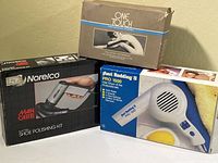 Three boxed items: Norelco shoe polisher, Jheri Redding hair dryer, One Touch hair removal kit