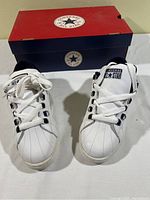 Pair of white Converse All Star men's Starwood OX sneakers size 7.5 with navy and silver accents, placed in front of Converse shoebox.