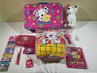 Full set showing pink hard-shell Spottie Dottie briefcase, plush white dog, plush pillow, zippered red pencil case, organizer pouch, pens, and small accessories