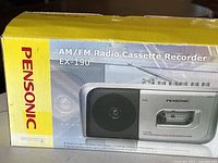 Photo of the yellow box showing the Pensonic AM/FM Radio Cassette Recorder EX-190 with image of the product on side, product branding, and condition notes visible.
