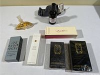 Photo showing six boxed perfume and cologne bottles plus two unboxed bottles on a flat surface.