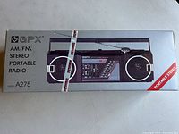 Box front showing GPX AM/FM stereo portable radio model A275, sealed with security tape.