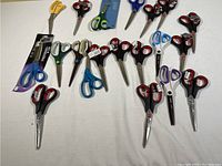 Photo showing full assortment of 16 scissors with various handle colors and some new in packaging.