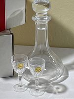 Close-up of a single crystal decanter and two liqueur glasses with 'Crystal' label, showing details of the items.