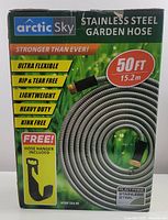 Box front showing branding, 50-foot length, stainless steel hose coiled, key features, and free hose hanger included.