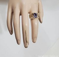 Ring worn on a mannequin hand, showing size and design.