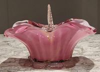 Side view of the pink opalescent art glass candy dish showing ruffled design and clear base