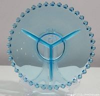 Front view of vintage blue glass divided dish showing three internal sections and hobnail edge detailing.