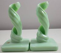 Pair of light green Westmoreland Jadeite glass candle holders standing side by side showing twisted spiral design and square bases.