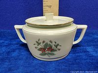 Front view of the sugar bowl with lid, showing floral pattern and gold trim.