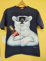 Front view of navy blue t-shirt with large polar bear and Coca-Cola bottle graphic.