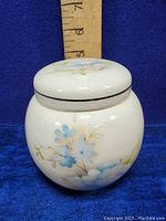 Front view of the closed Sadler England ginger jar showing blue flower design and lid with ruler for scale.